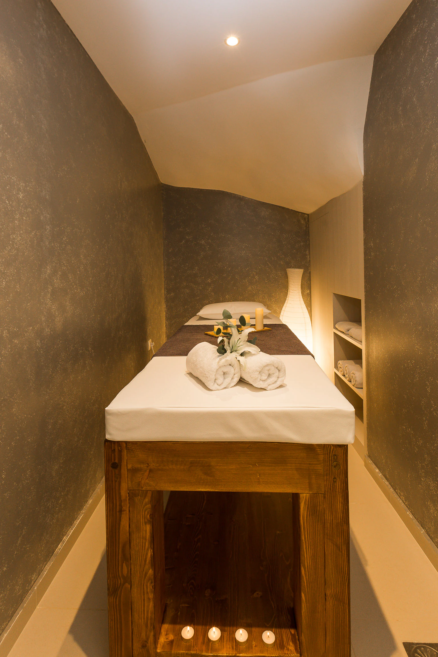 Private massage room with a prepared treatment bed
