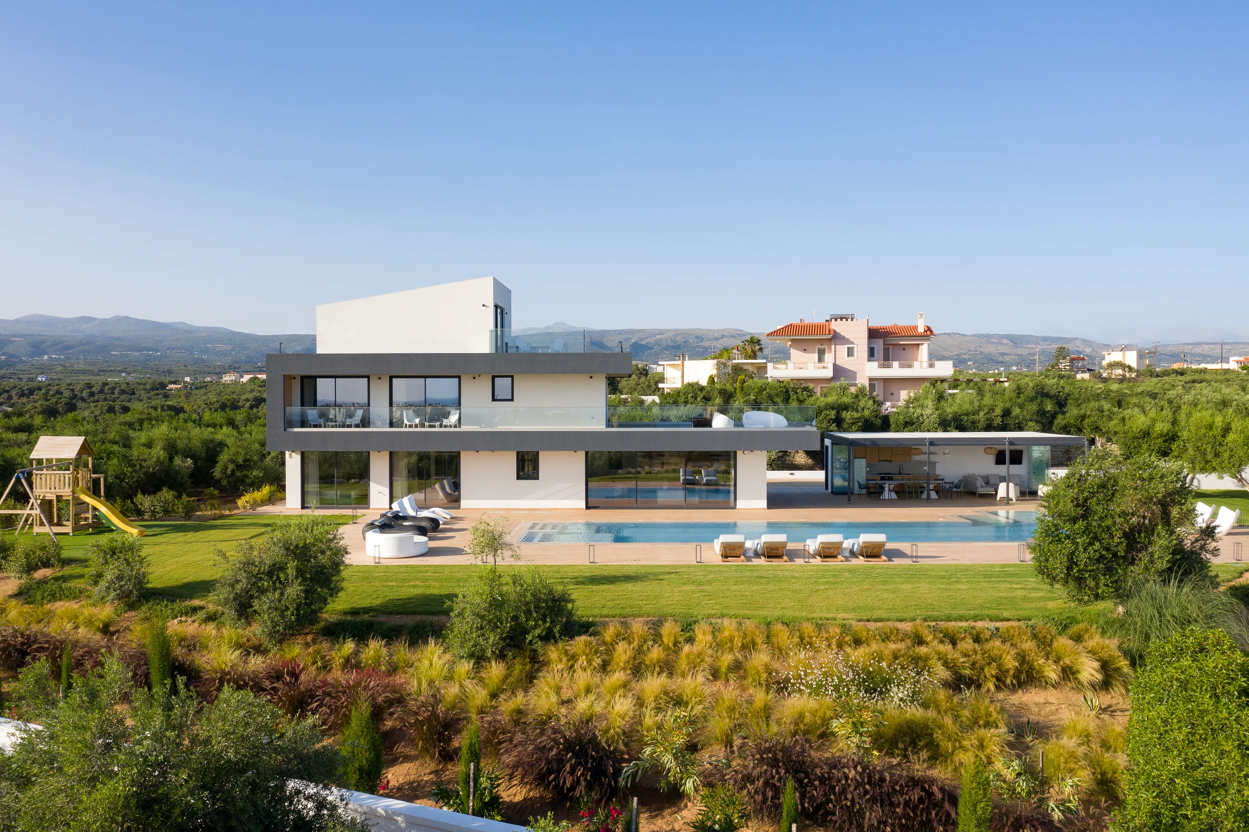 Aerial view of the villa, lawns and long outdoor pool at Aesthea Exclusive Villa