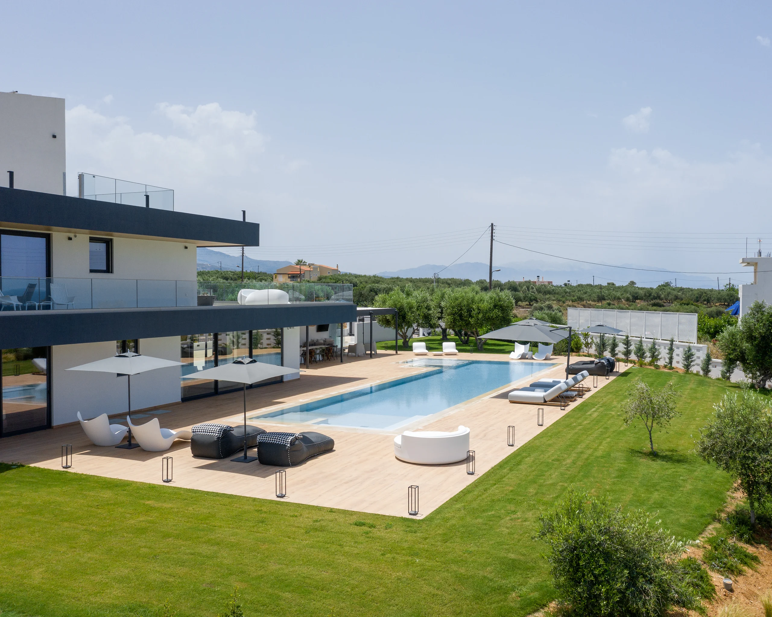 Wide estate view with the villa, pool, lawn and playground at Aesthea Exclusive Villa