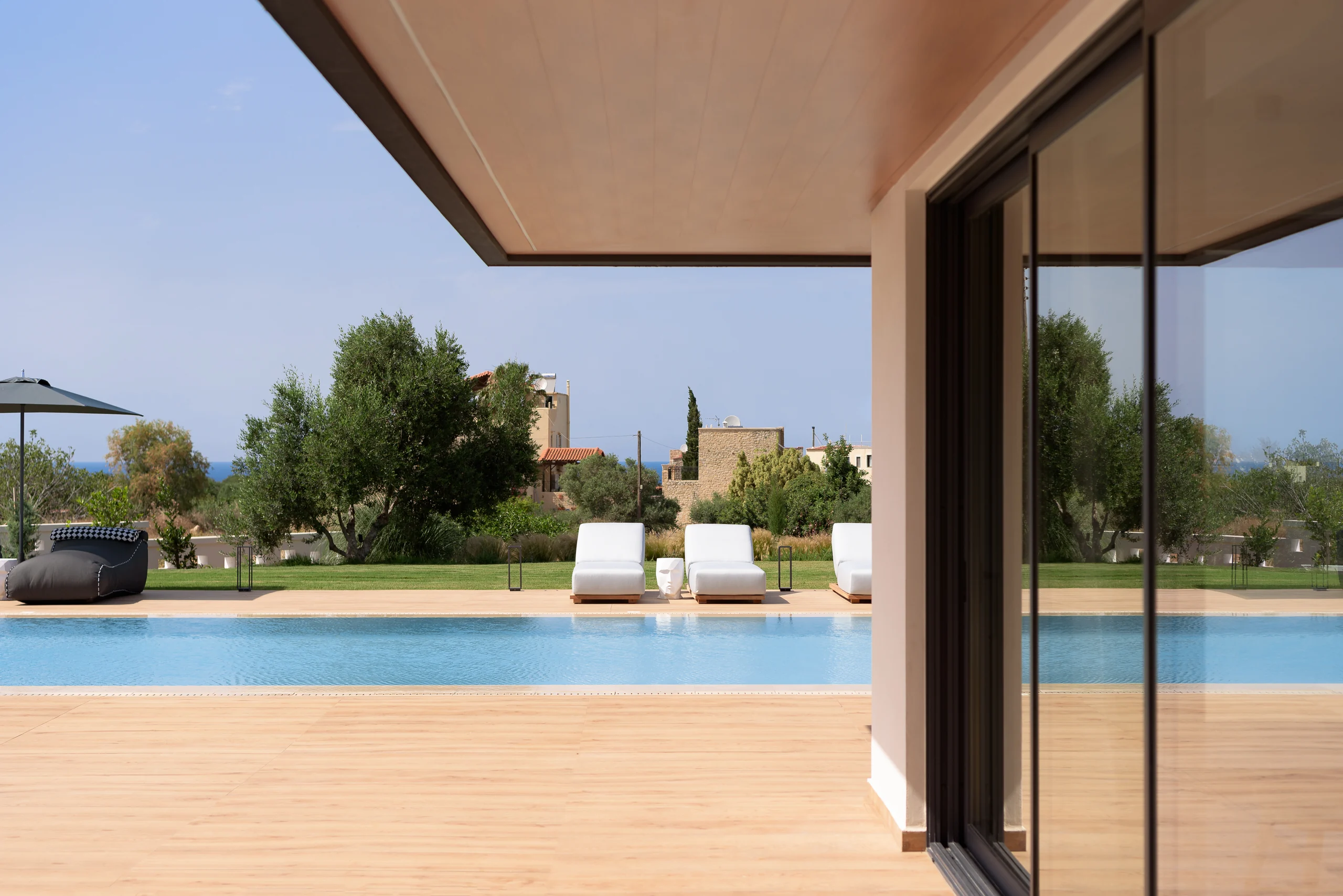 View from the living-room glazing onto the pool terrace at Aesthea Exclusive Villa