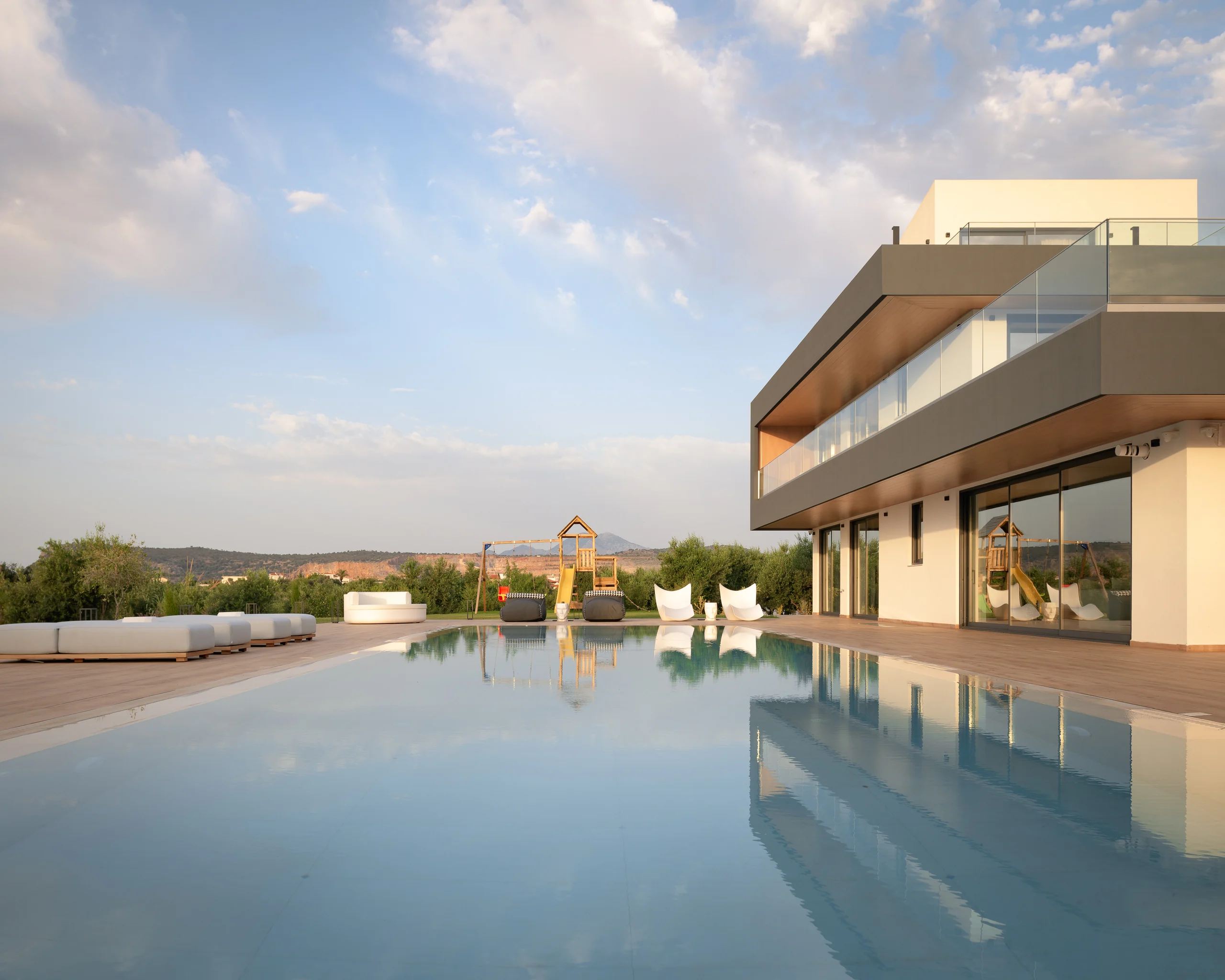 Golden-hour reflection of the villa across the pool at Aesthea Exclusive Villa