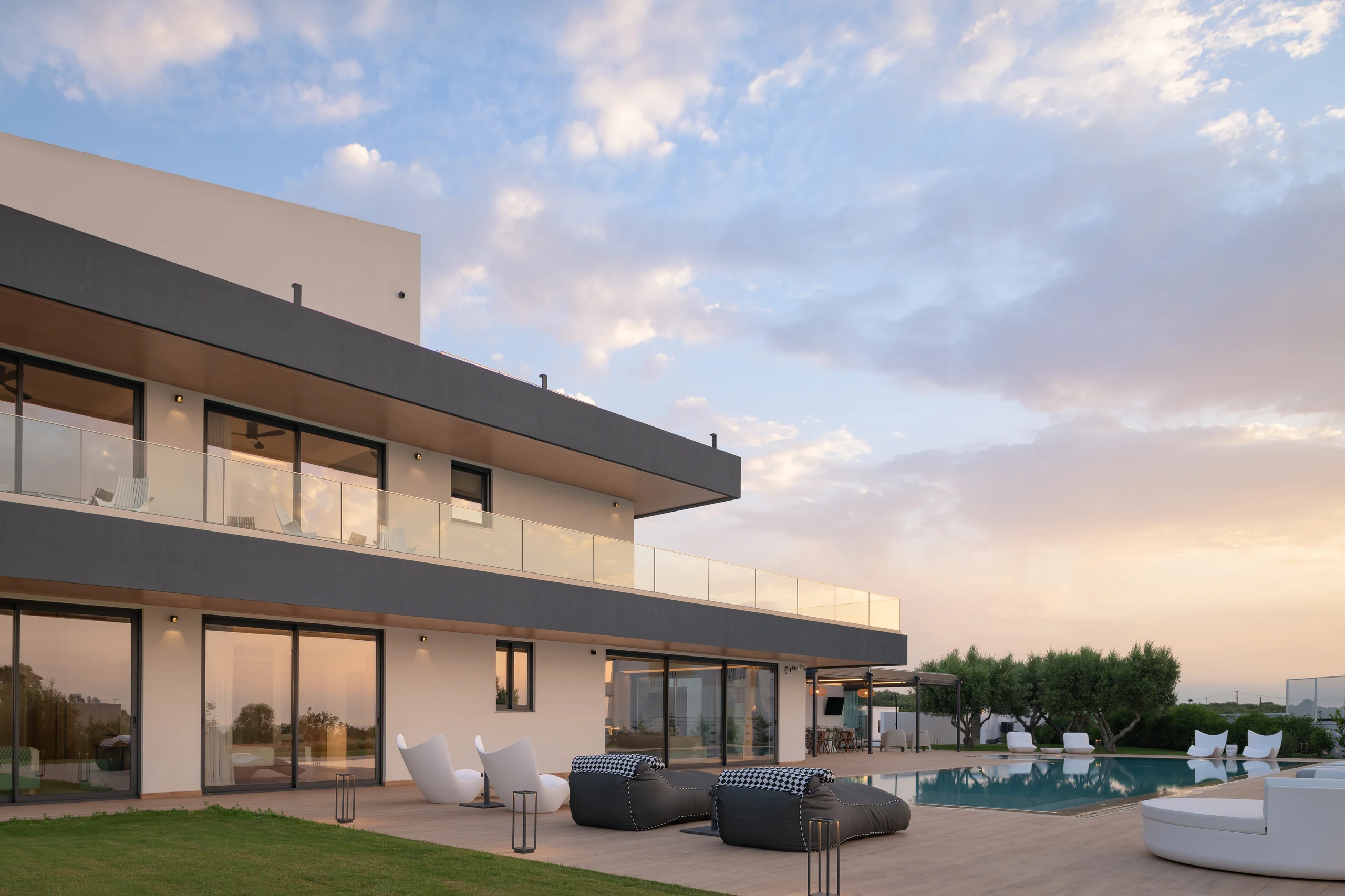 Alfresco terrace seating overlooking the illuminated pool at Aesthea Exclusive Villa