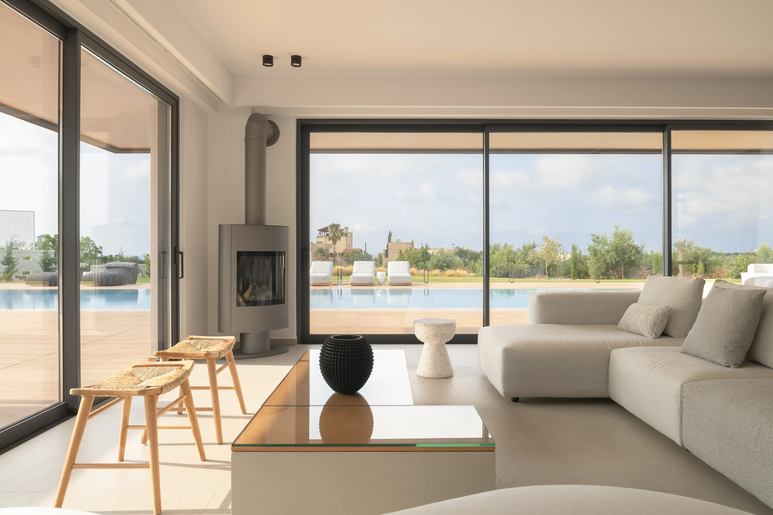 Main living area with full-height glazing overlooking the pool at Aesthea Exclusive Villa