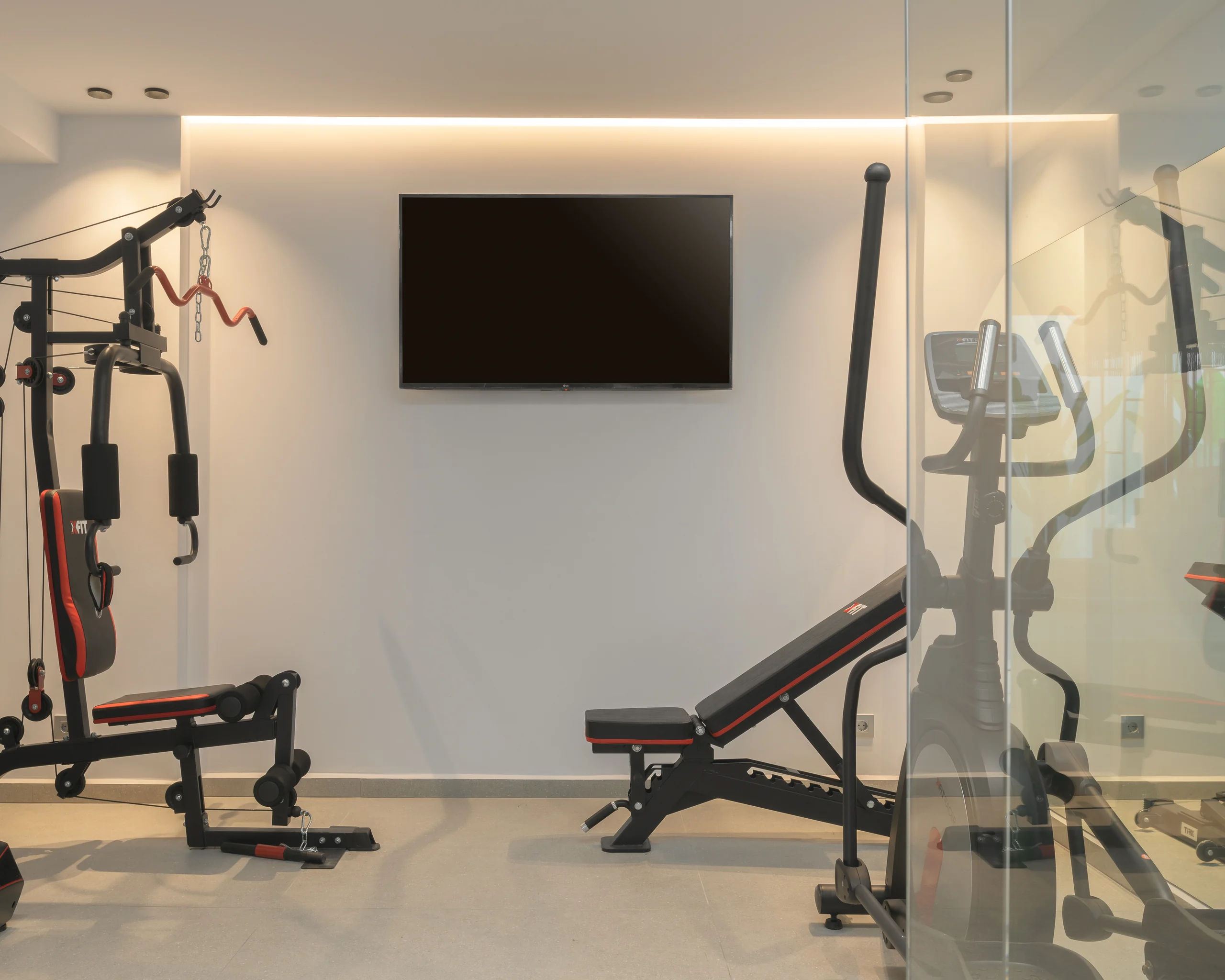 Private gym equipped with weights, a bench and cardio machines at Aesthea Exclusive Villa