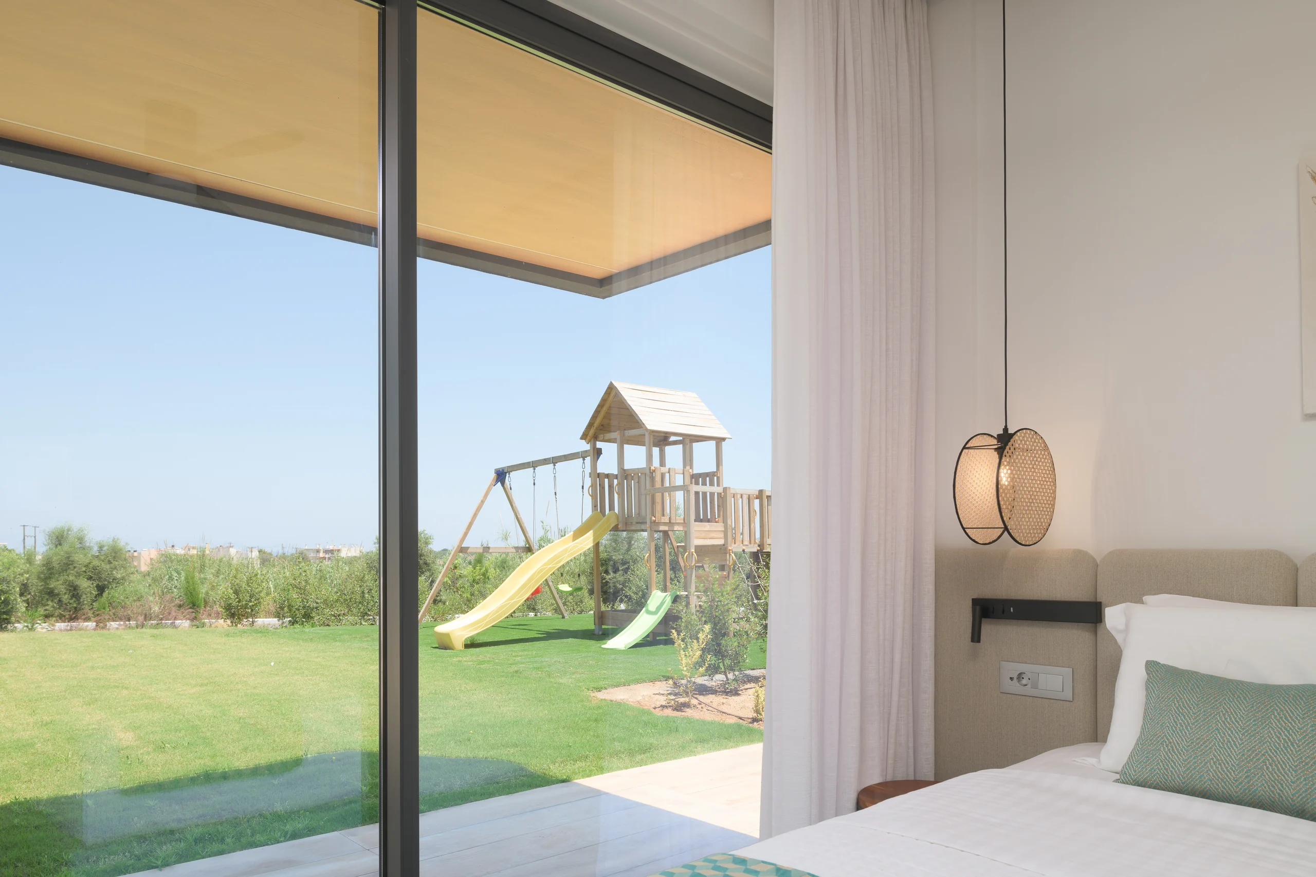 Ground-floor Bedroom 2 looking across the lawn to the playground at Aesthea Exclusive Villa