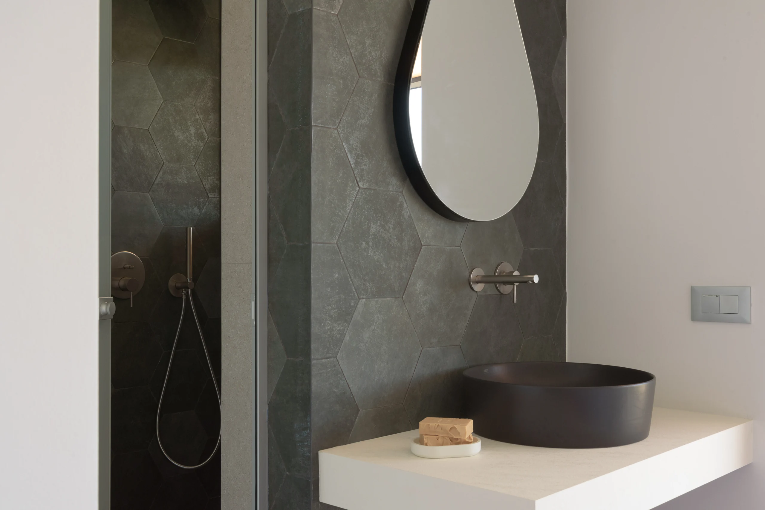 Dark stone basin and glass shower in the ensuite of First-floor Bedroom 1 at Aesthea Exclusive Villa