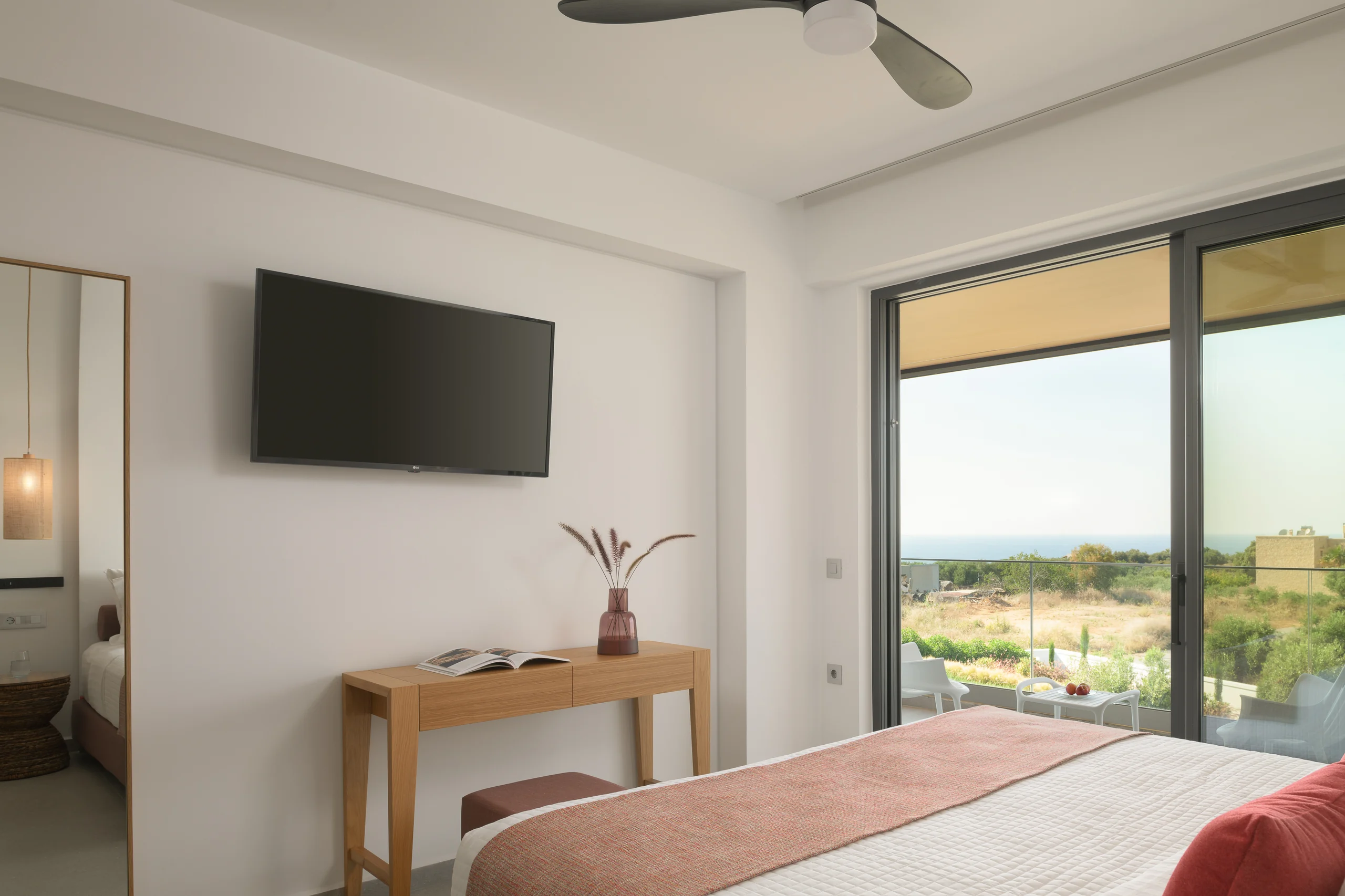 Television and writing desk beside the balcony view in First-floor Bedroom 3 at Aesthea Exclusive Villa