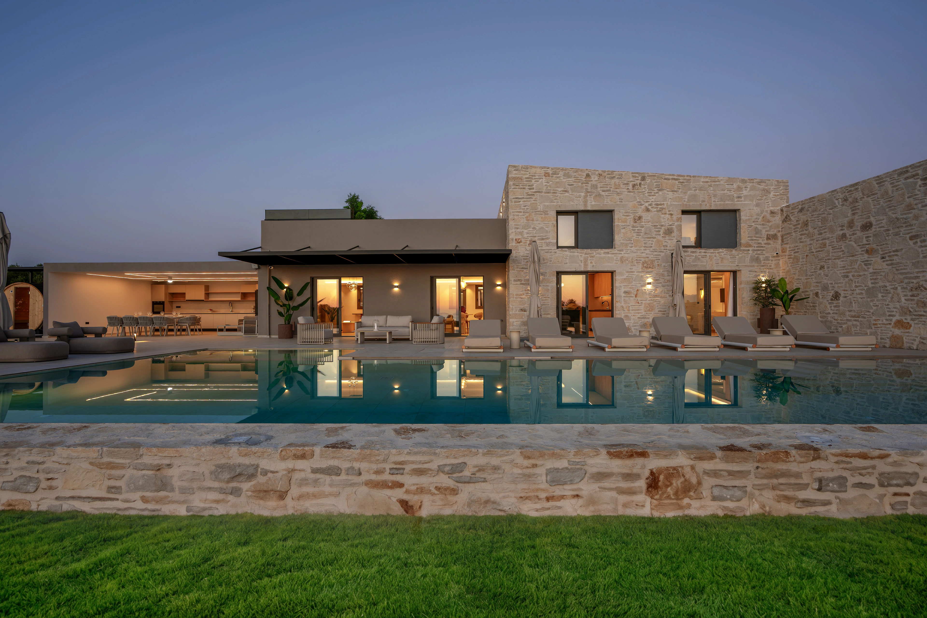 Right Crete facade, pool and outdoor lounge at blue hour