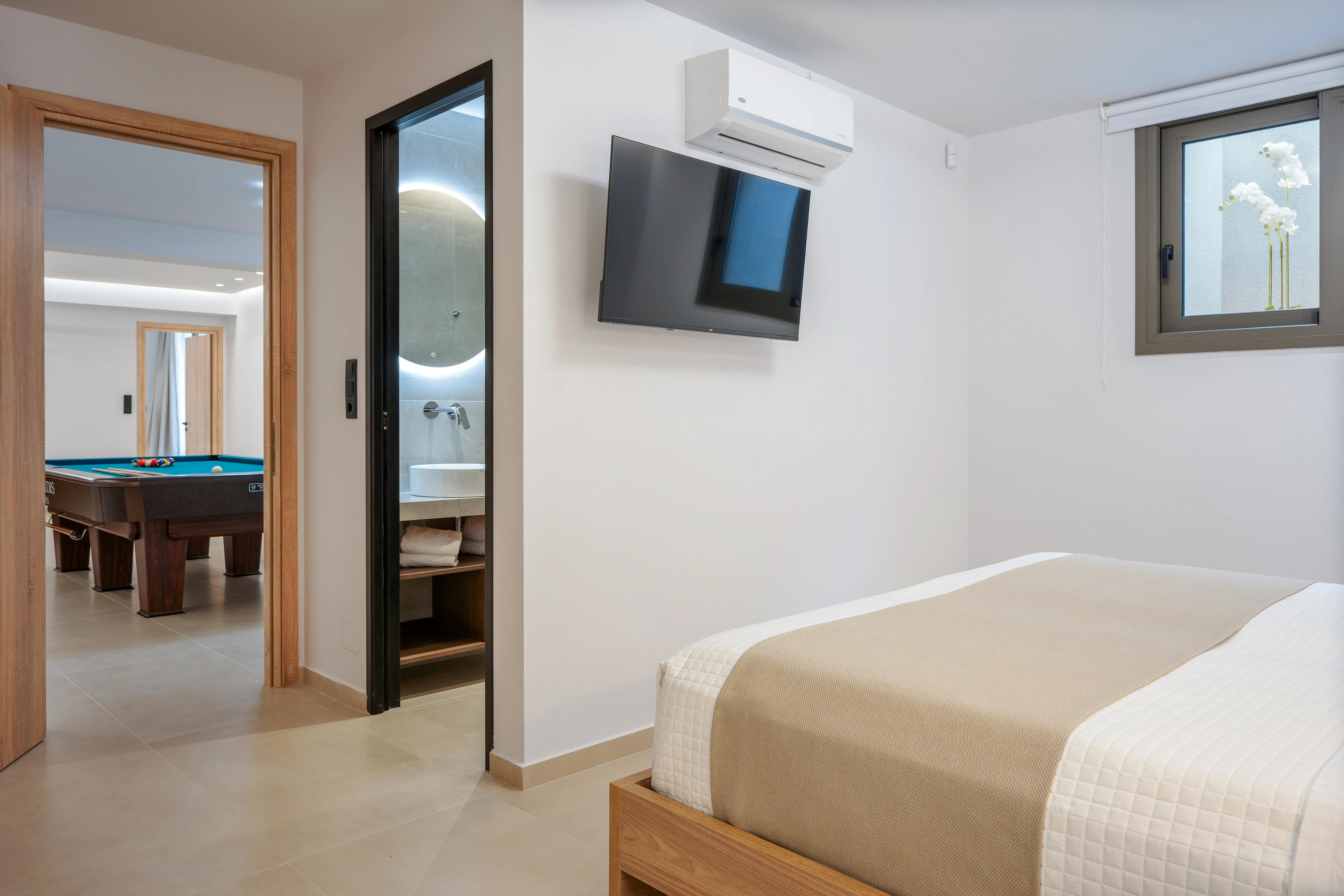 Left Crete bedroom 01 showing its king-size bed, television and doorway to the private bathroom