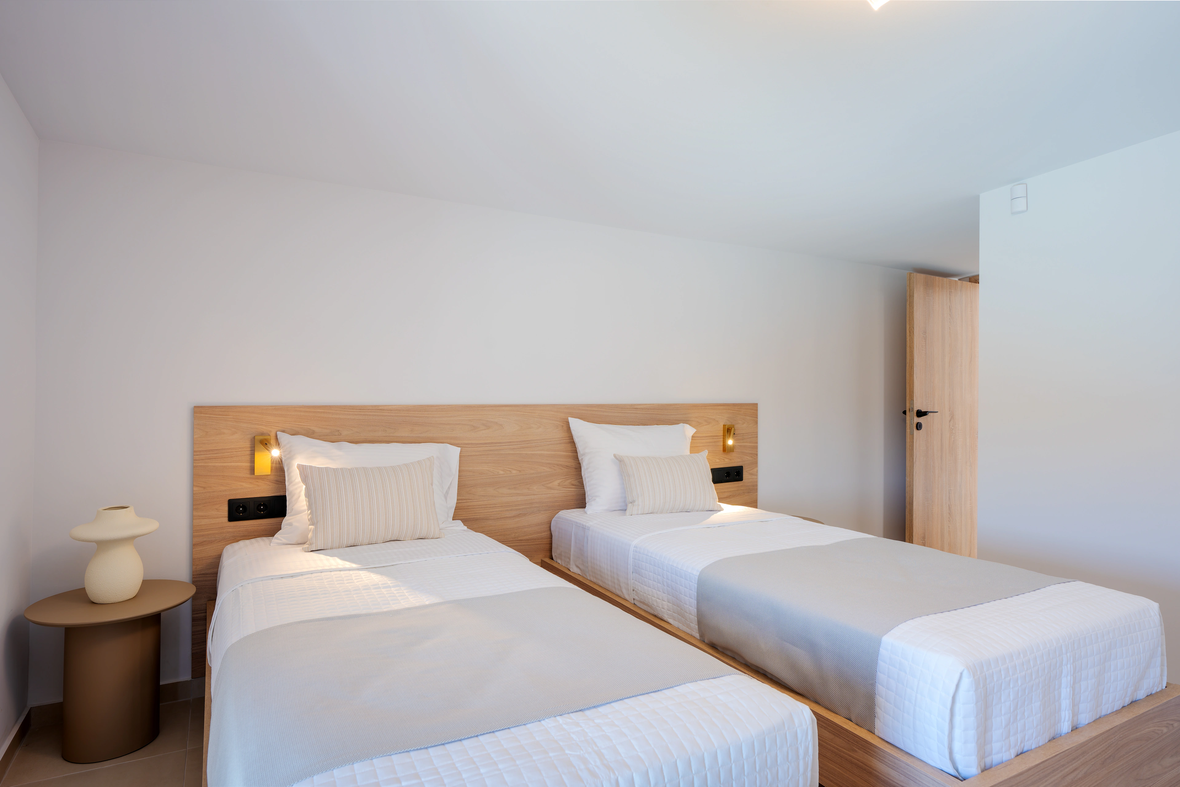 King-size bed and warm headboard lighting in Left Crete bedroom 03