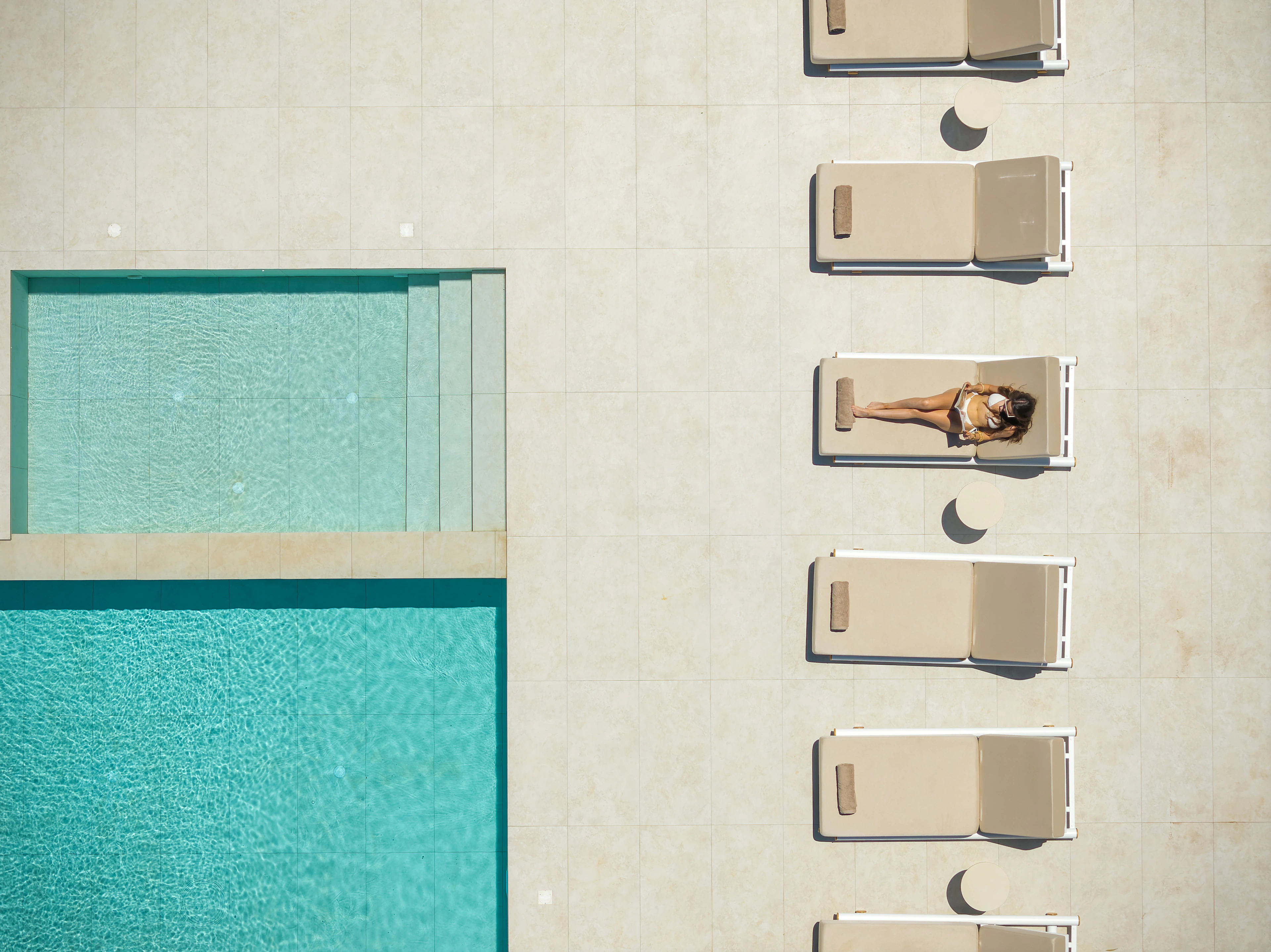 A guest relaxing beside Right Crete's pool and sun loungers from above