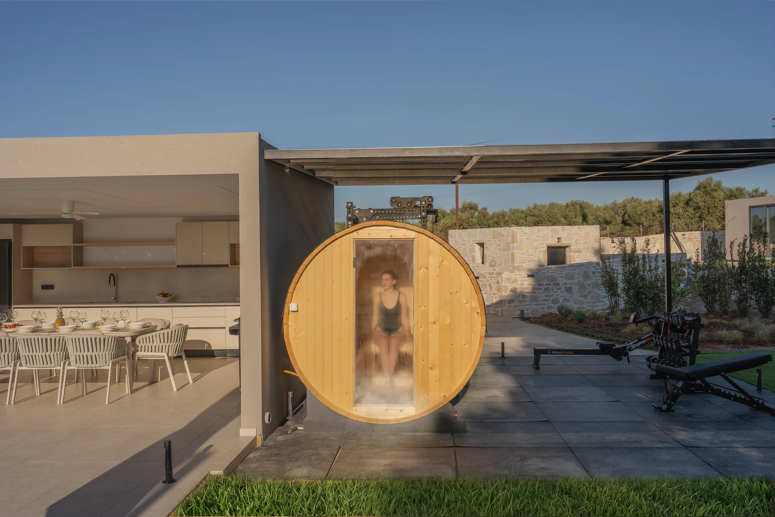 Left Crete's private timber barrel sauna beside the outdoor kitchen and gym