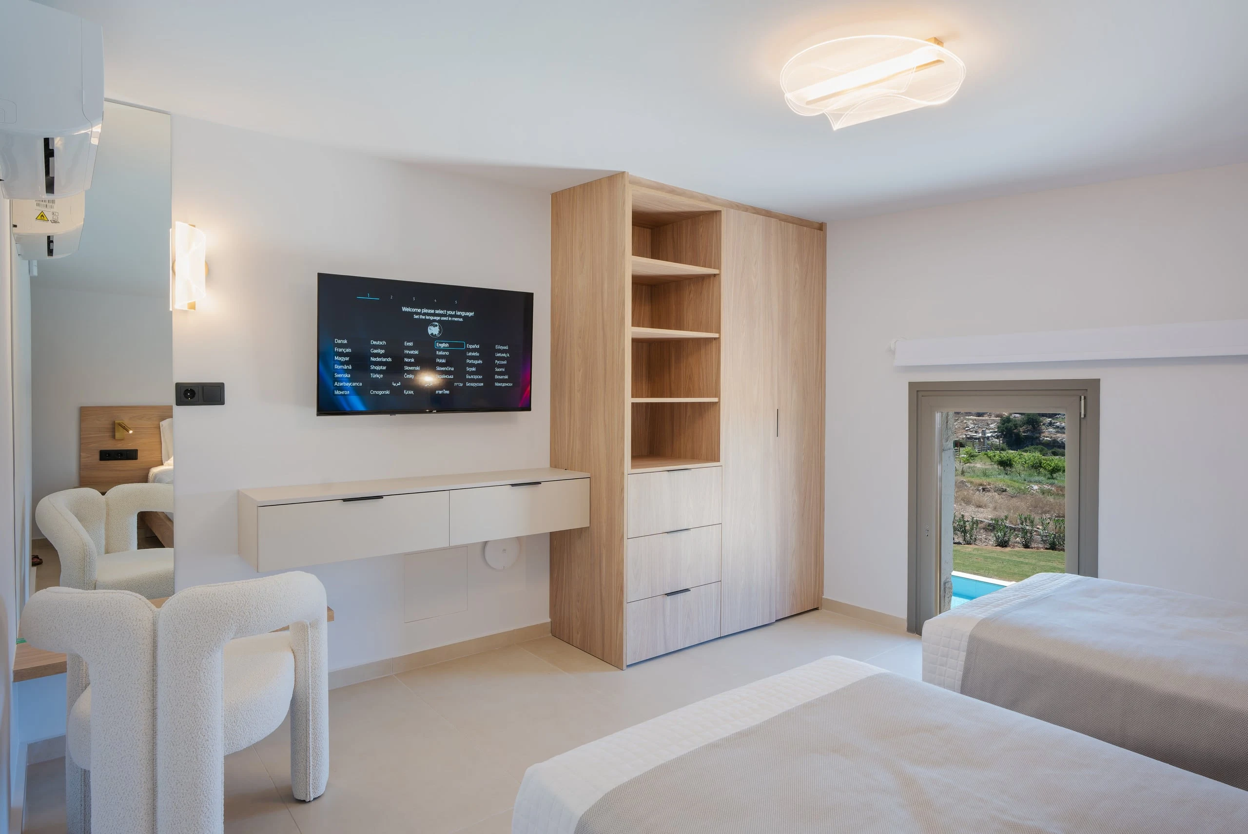 Left Crete bedroom 04 with two single beds, television, desk and a pool-facing window